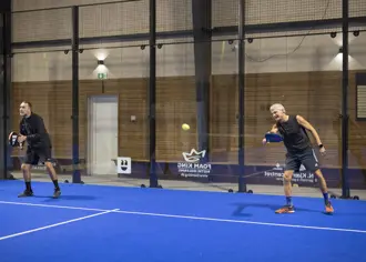 Two men playing padel tennis
